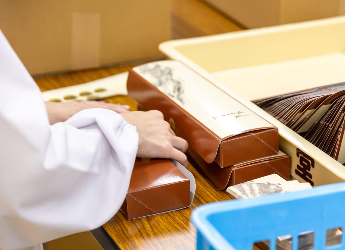 お菓子を箱に詰める様子の画像